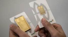 Karyawan menunjukkan sampel emas batangan di Butik Emas Logam Mulia PT. Aneka Tambang (ANTAM), Semarang, Jawa Tengah. 