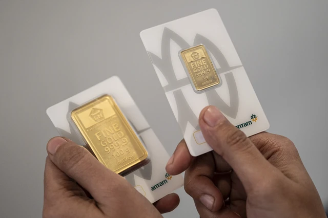 Karyawan menunjukkan sampel emas batangan di Butik Emas Logam Mulia PT. Aneka Tambang (ANTAM), Semarang, Jawa Tengah. 