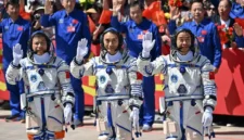 Para astronaut misi luar angkasa Shenzhou-20 Tiongkok (kiri) Wang Jie, Chen Zhongrui, dan Chen Dong melambaikan tangan saat upacara keberangkatan sebelum menaiki bus untuk membawa mereka ke pesawat luar angkasa Shenzhou-20 di Pusat Peluncuran Satelit. Foto: Pedro PARDO / AFP