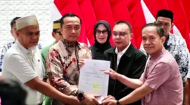 Surat rehabilitasi Presiden Prabowo kepada dua guru asal Kabupaten Luwu Utara, Sulawesi Selatan, Abdul Muis (kiri) dan Rasnal (kanan), Kamis (13/11/2025). Mereka didampingi Mensesneg Prasetyo dan Wakil Ketua DPR Sufmi Dasco. Foto: Dok. Kemensetneg