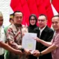 Surat rehabilitasi Presiden Prabowo kepada dua guru asal Kabupaten Luwu Utara, Sulawesi Selatan, Abdul Muis (kiri) dan Rasnal (kanan), Kamis (13/11/2025). Mereka didampingi Mensesneg Prasetyo dan Wakil Ketua DPR Sufmi Dasco. Foto: Dok. Kemensetneg