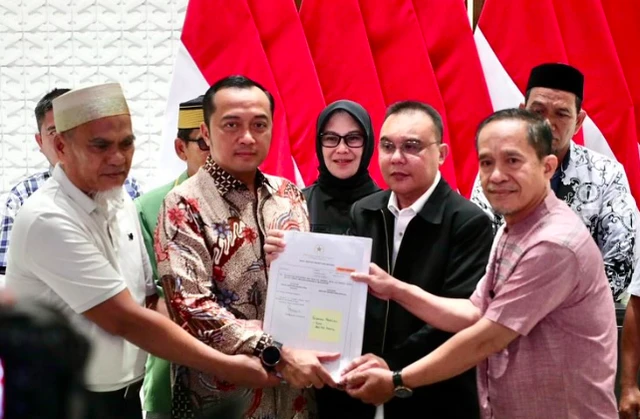 Surat rehabilitasi Presiden Prabowo kepada dua guru asal Kabupaten Luwu Utara, Sulawesi Selatan, Abdul Muis (kiri) dan Rasnal (kanan), Kamis (13/11/2025). Mereka didampingi Mensesneg Prasetyo dan Wakil Ketua DPR Sufmi Dasco. Foto: Dok. Kemensetneg