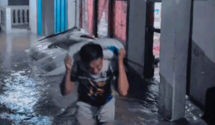 Warga Siulak, Kerinci memindahkan padi dari banjir.